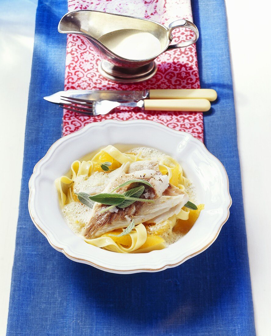 Oven-baked sea bream on ribbon pasta with orange sauce