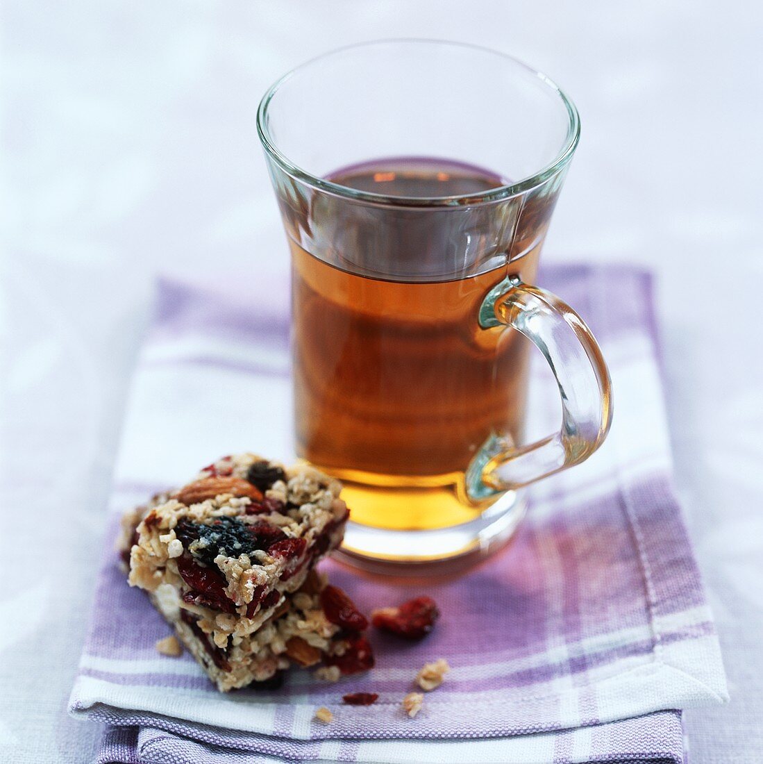 A glass of herbal tea with a muesli bar