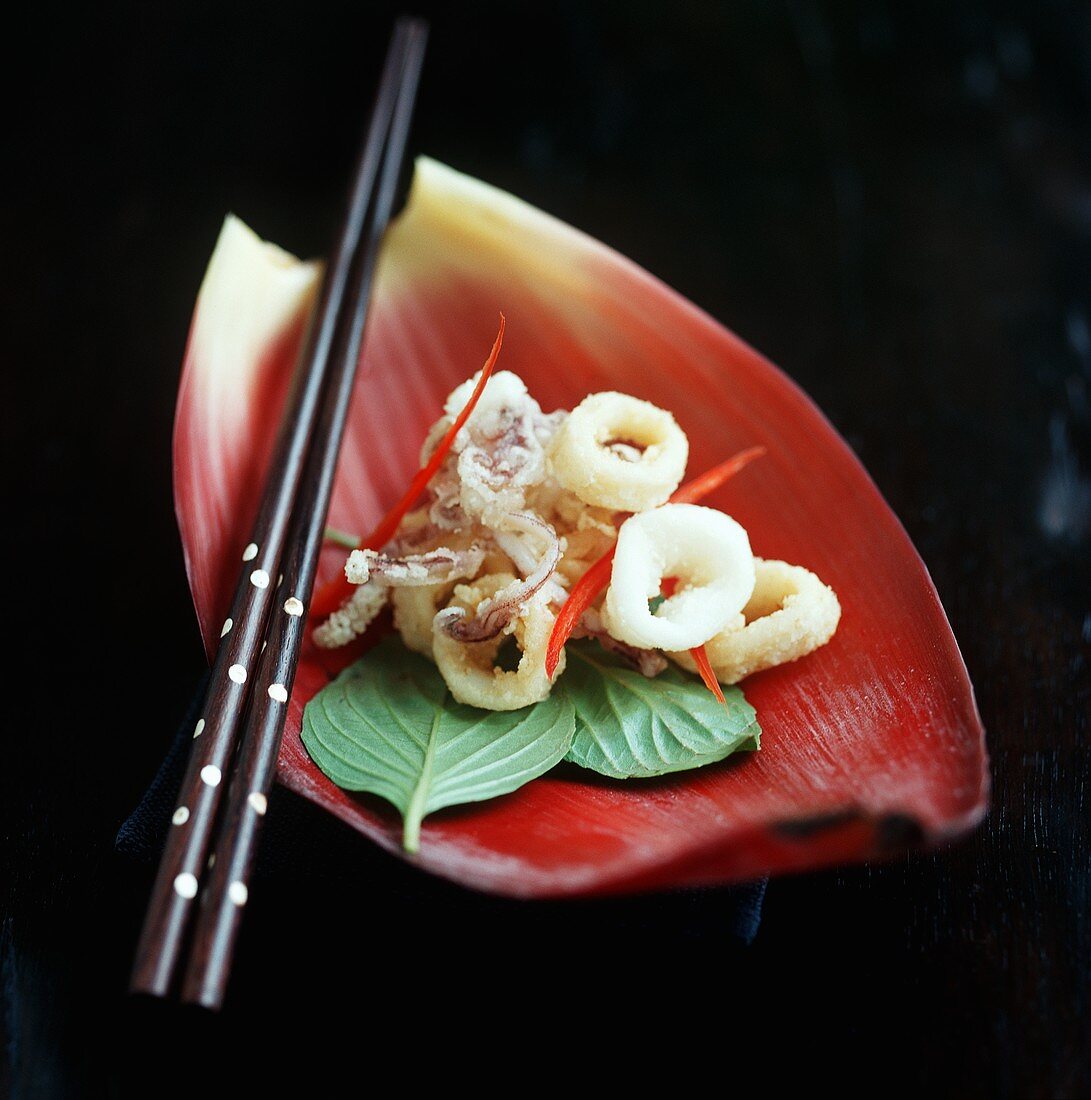 Deep-fried squid with fried basil on banana flower petal