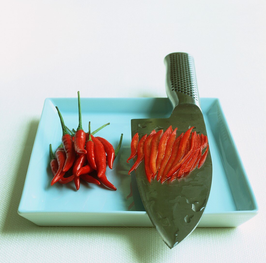 Whole and sliced chillies with a knife