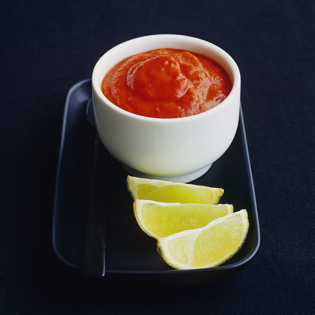 Chilli sauce with lime wedges