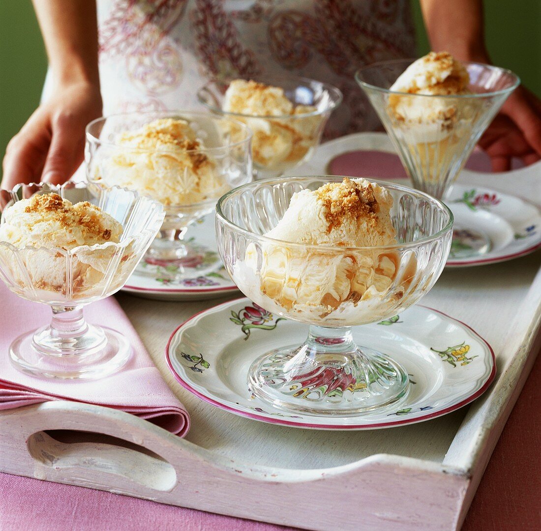 Several ice cream sundaes with nuts on a tray