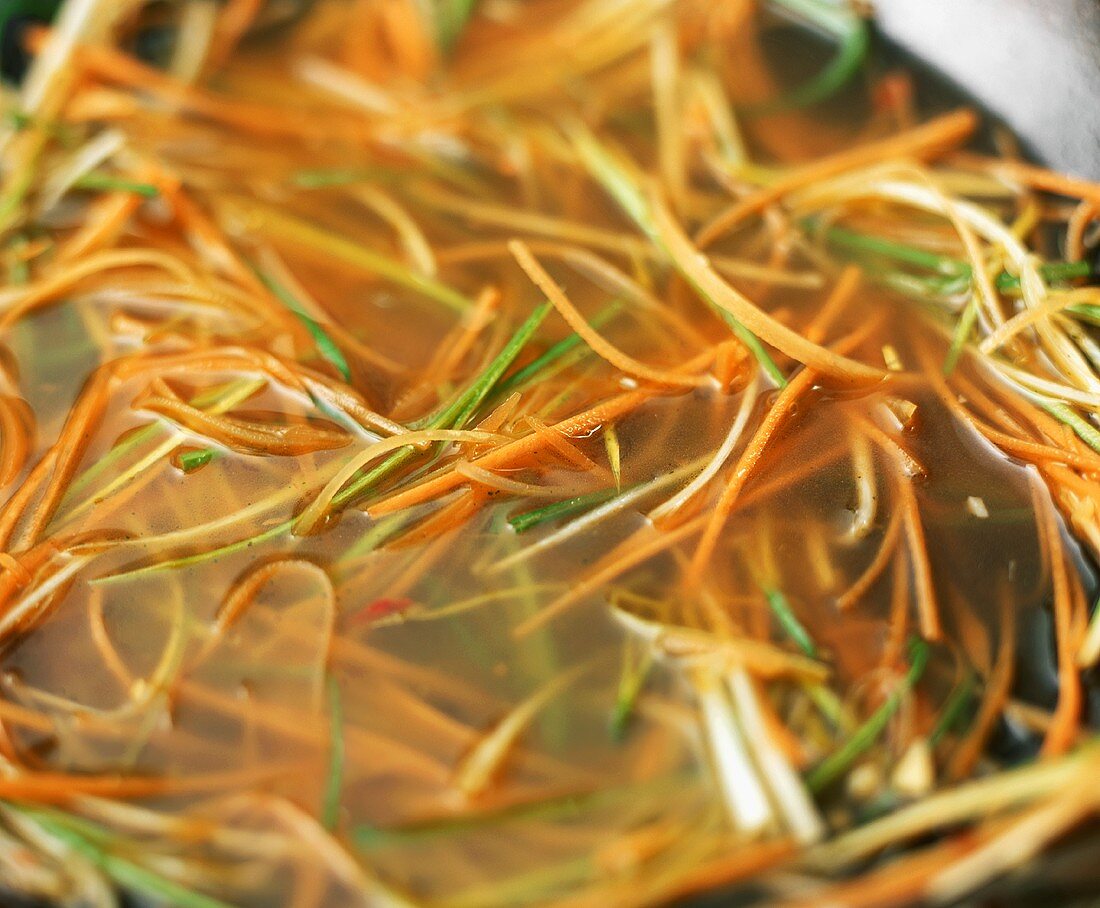 Soup with sliced vegetables in a wok