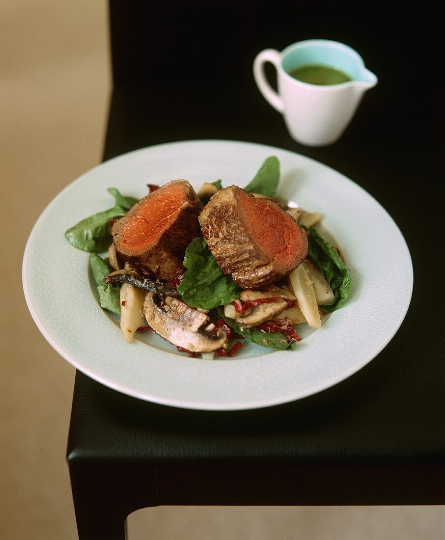 Beef fillet on a spinach salad with mushrooms
