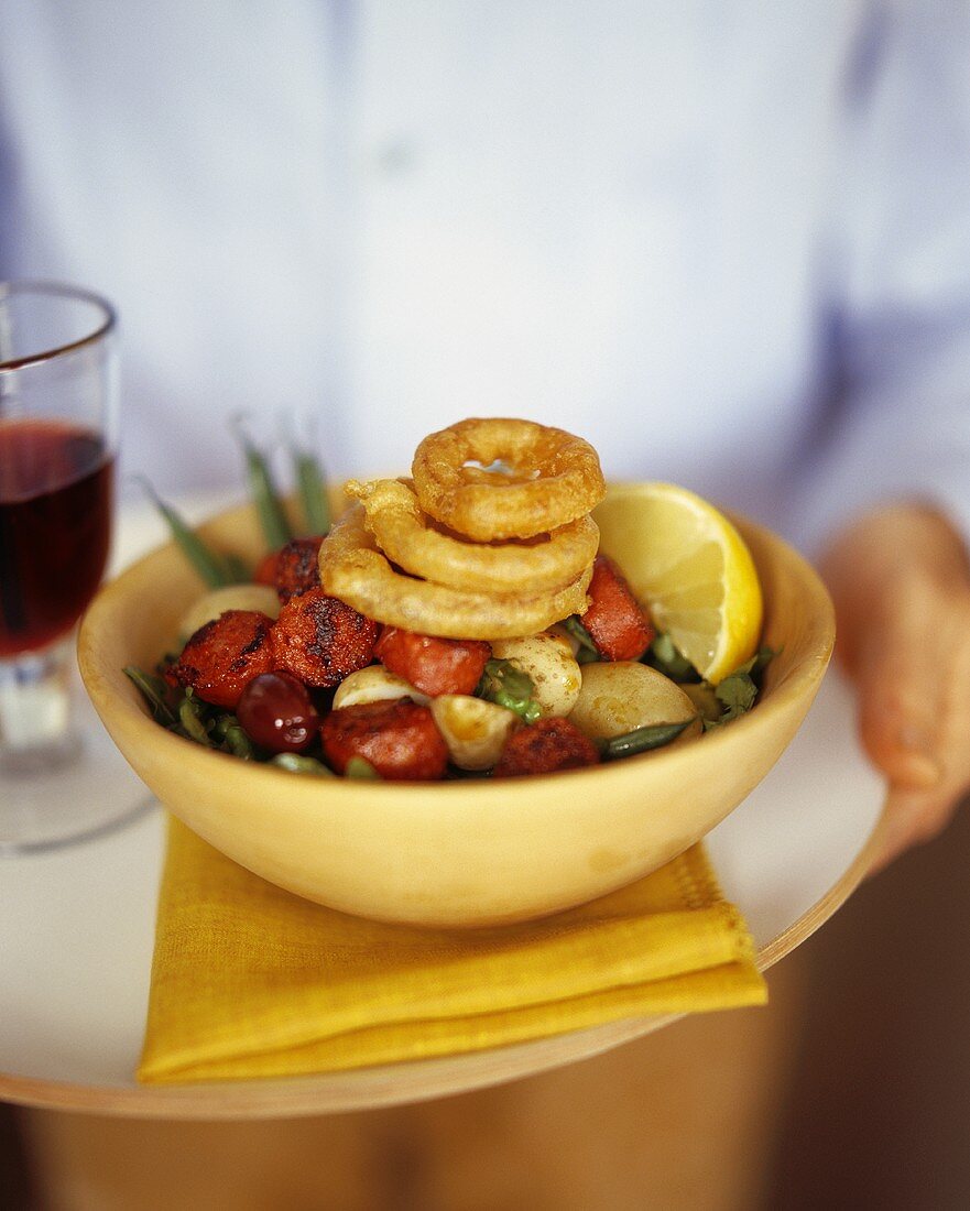 Vegetable salad with sausages and fried calamari