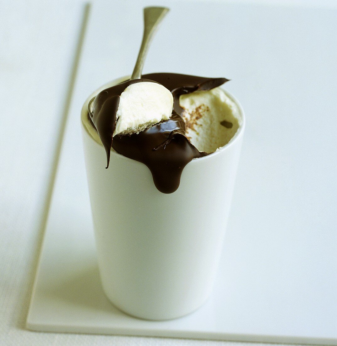 Ein Becher Vanilleeis mit Schokoladensauce