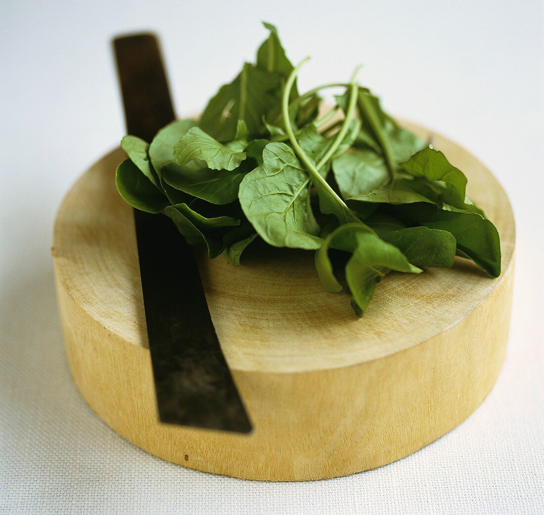 Betel leaves on a wooden board with a knife