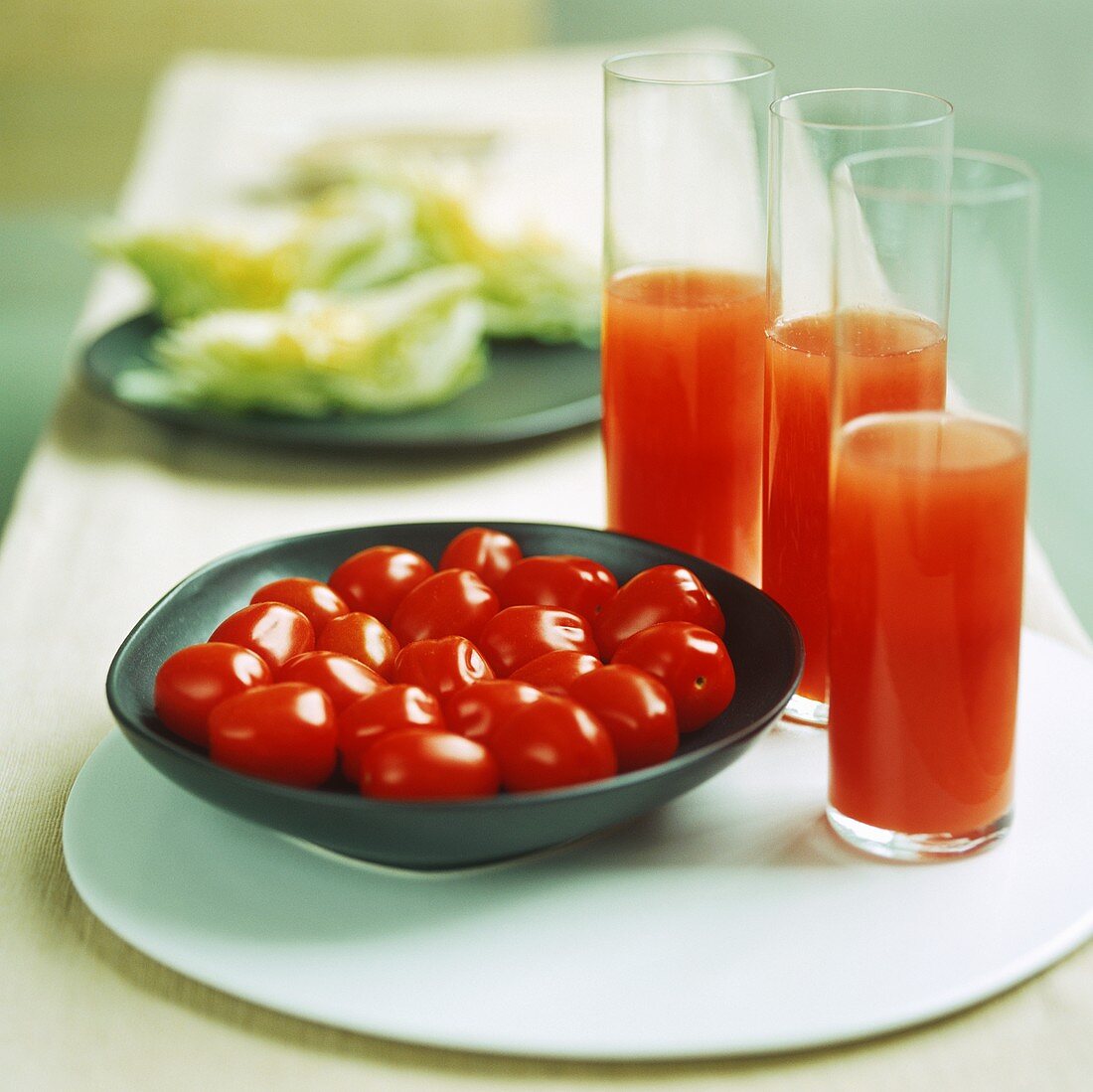 Three glasses of tomato juice with fresh tomatoes
