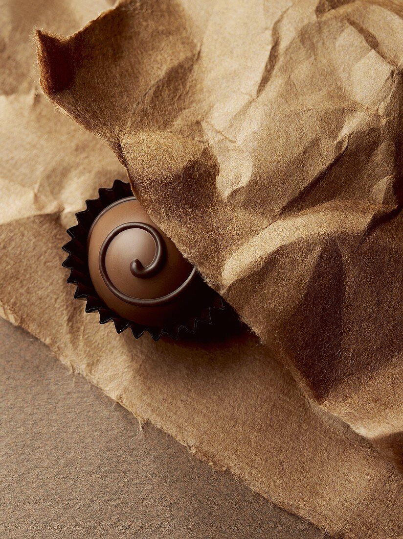 A chocolate on brown paper