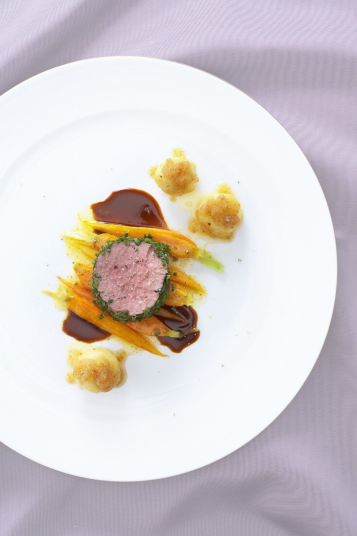 Poached veal fillet in a herb crust with carrots and dumplings