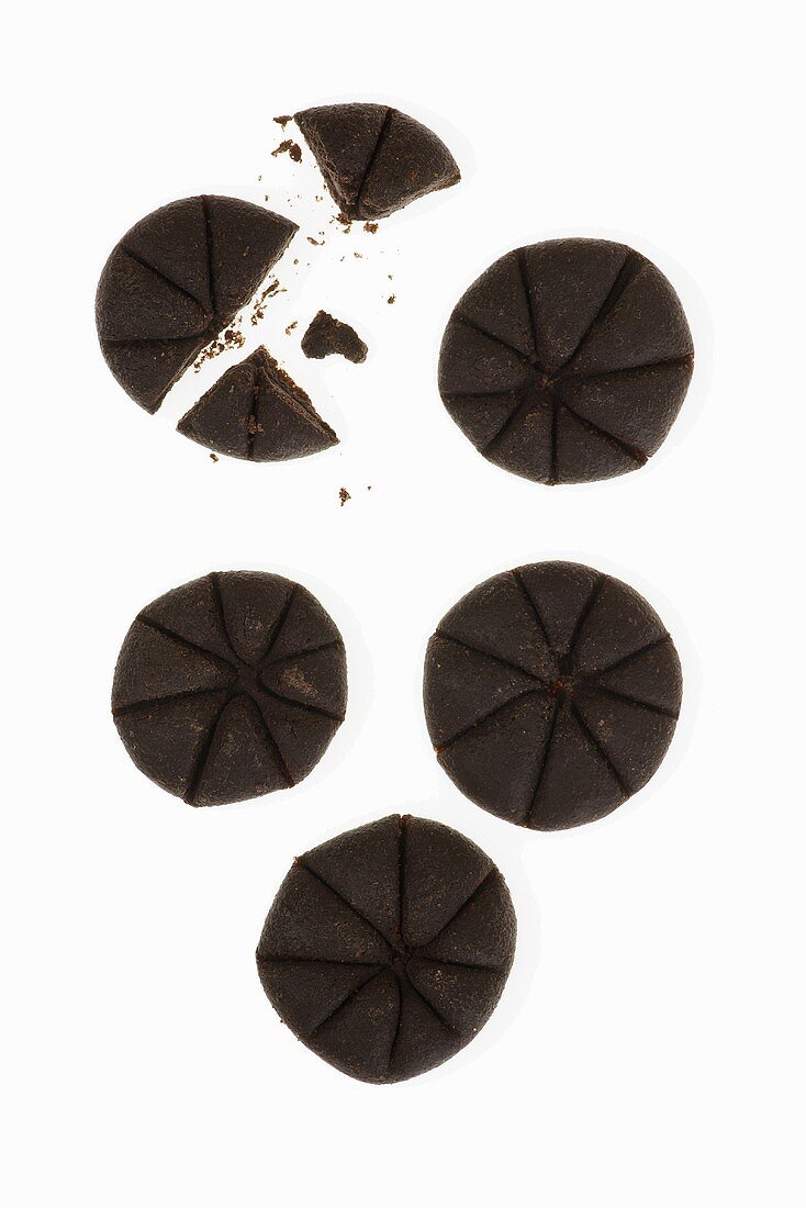Five chocolate biscuits on a white surface
