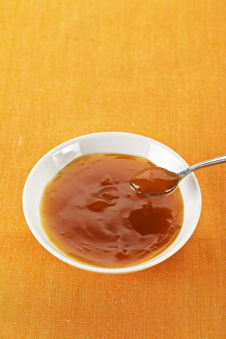Apricot jam in a bowl and on a spoon