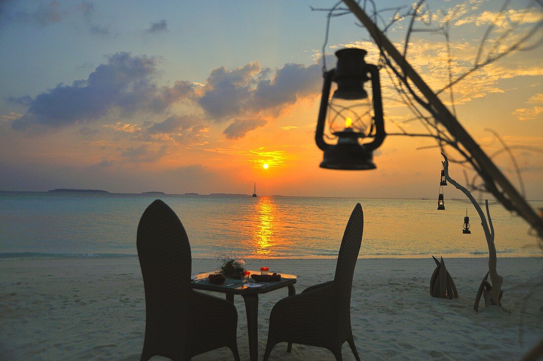 A romantic candlelight dinner on the beach at sunset