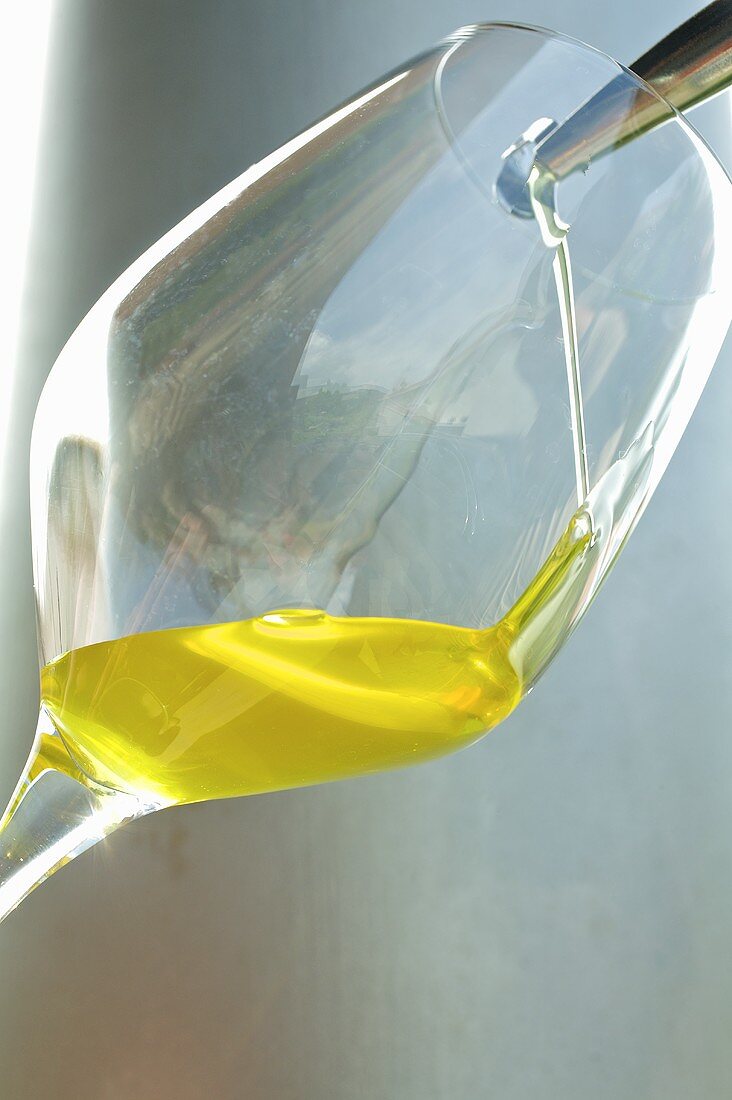Olive oil being poured into a glass
