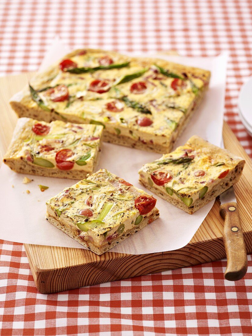 Tomato and asparagus quiche on a chopping board