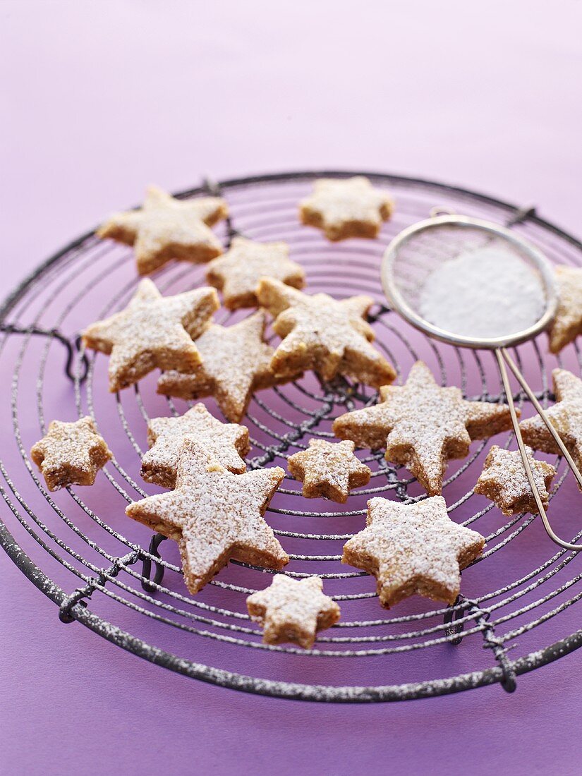 Cinnamon stars with icing sugar on a wire rack