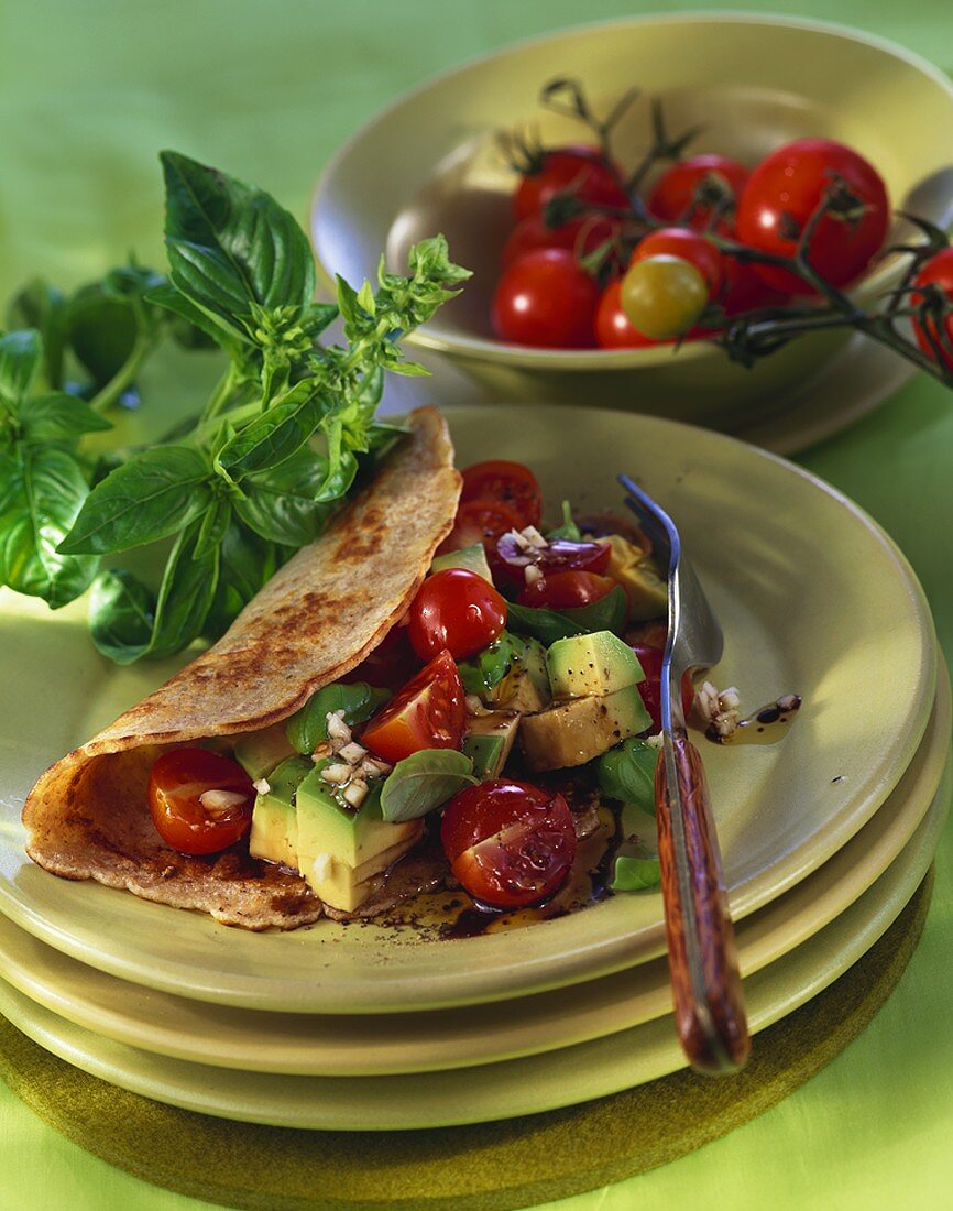 Pancake filled with avocado and tomato salad