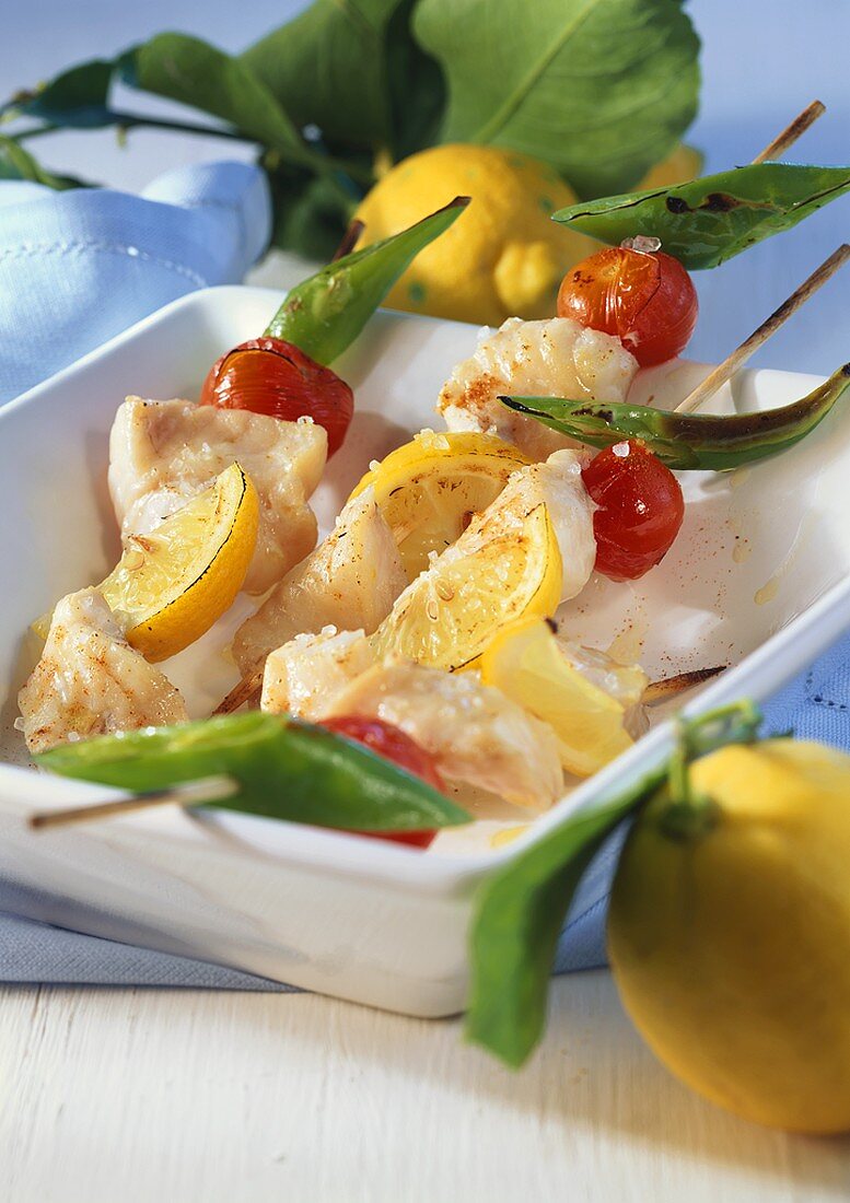 Fish kebabs with cocktail tomatoes and lemons