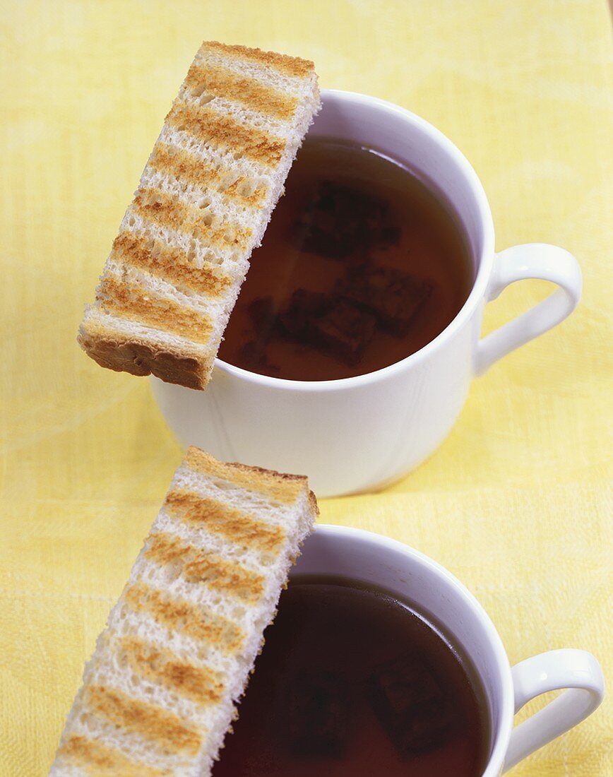 Clear oxtail soup with fingers of toast