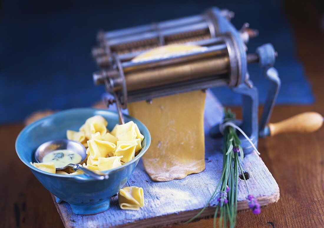 Pasta maker and filled pasta parcels with spinach sauce