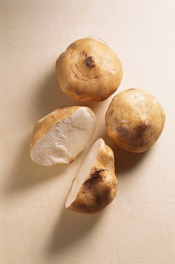 Drei Süßkartoffeln, ganz und angeschnitten