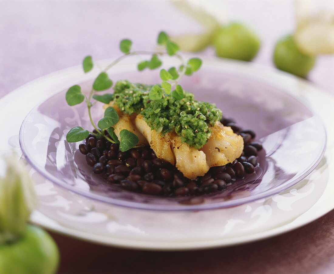 Cod fillet with green salsa on black beans