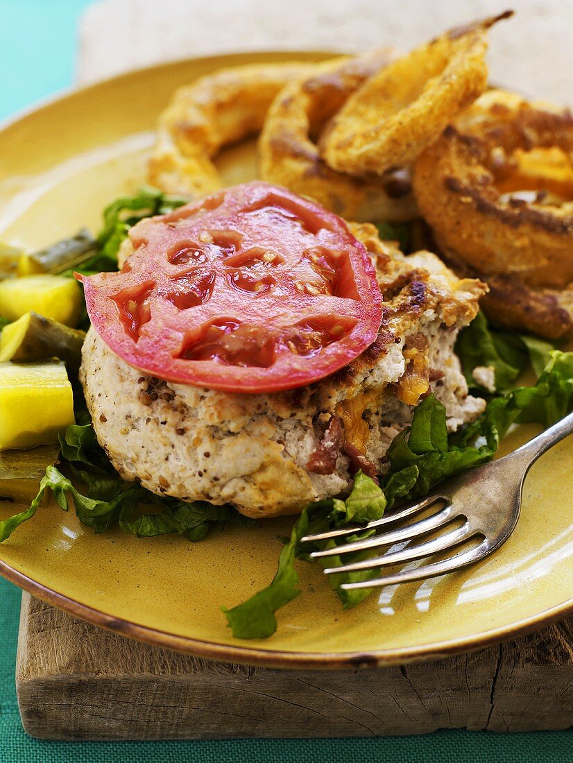 Putenfrikadelle mit Tomate und frittierten Zwiebelringen