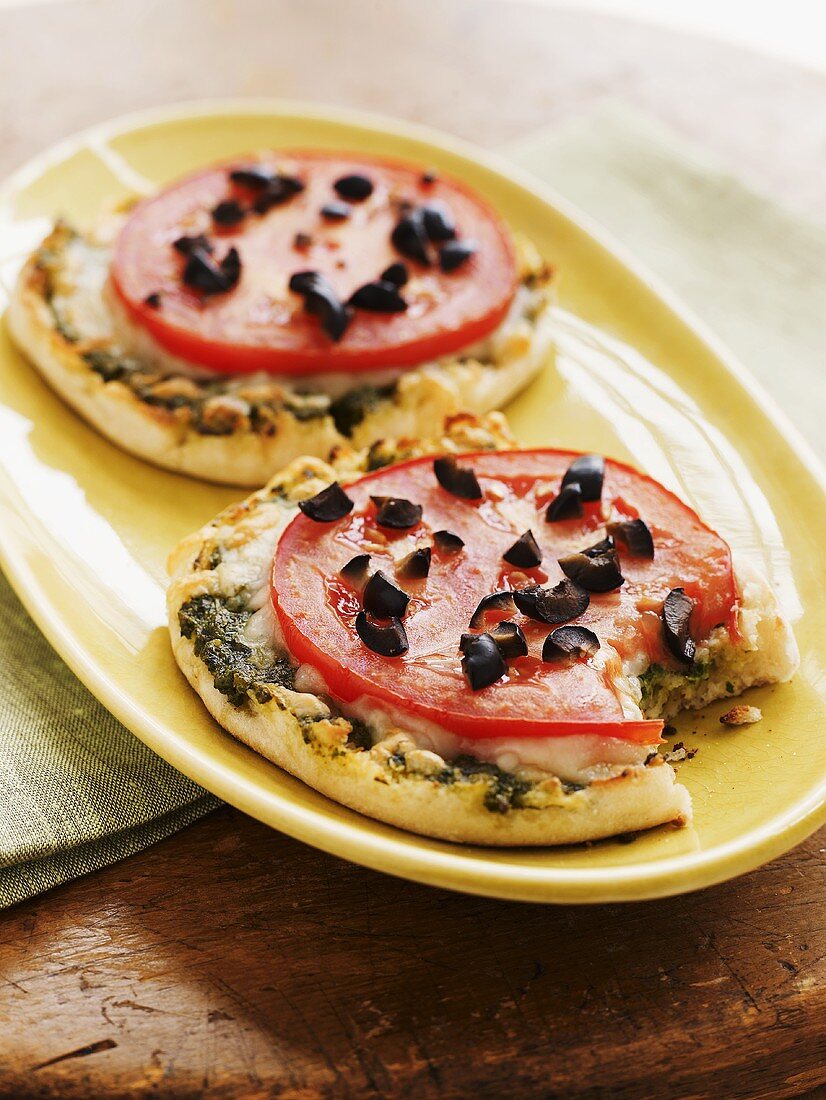 English muffin pizzas topped with tomatoes & chopped olives