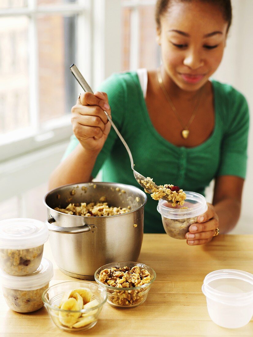 Woman putting cereal into containers to take away