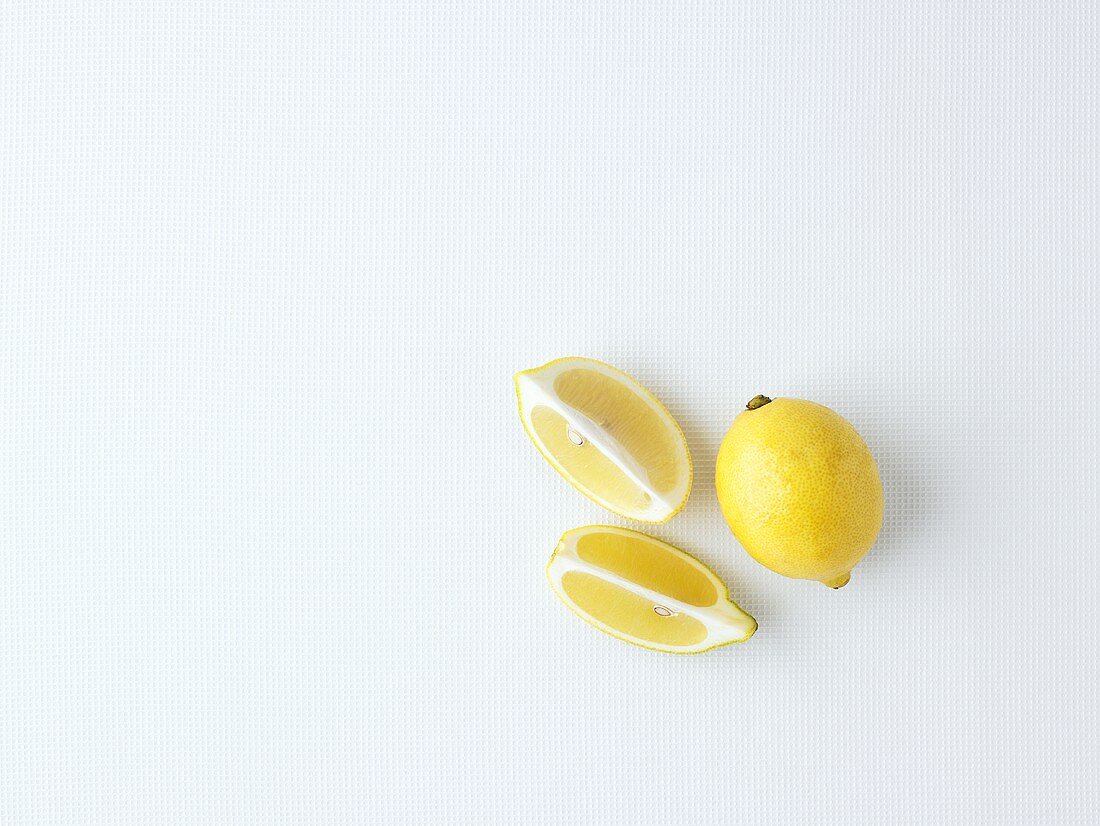 Ganze Zitrone und Zitronenschnitze