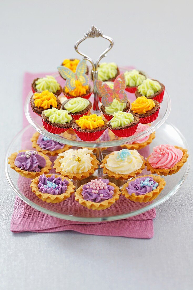 Cupcakes and cream tarts on tiered stand