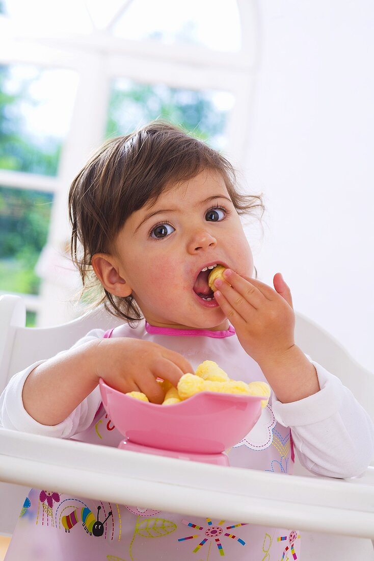Kleines Mädchen isst Maischips