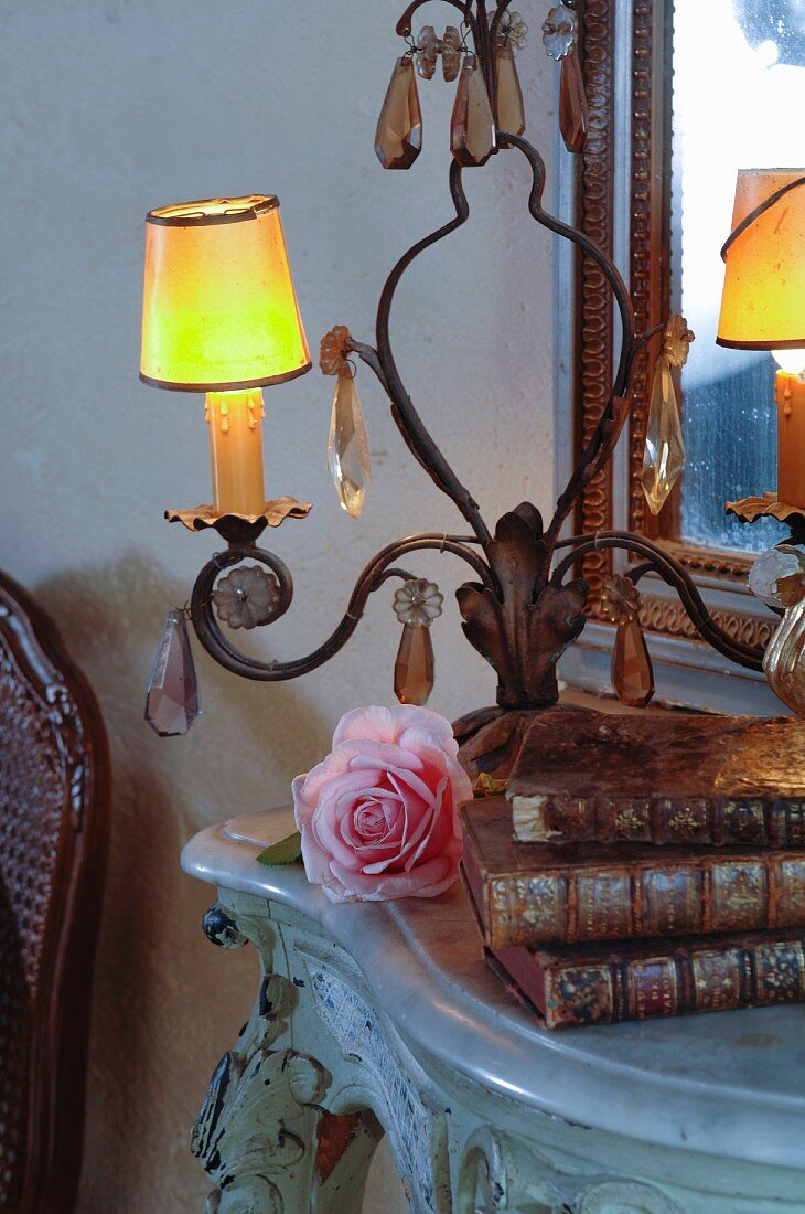 Light and antique books on side table