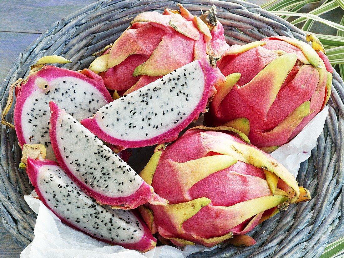 Whole pitahayas and pieces of pitahaya in basket