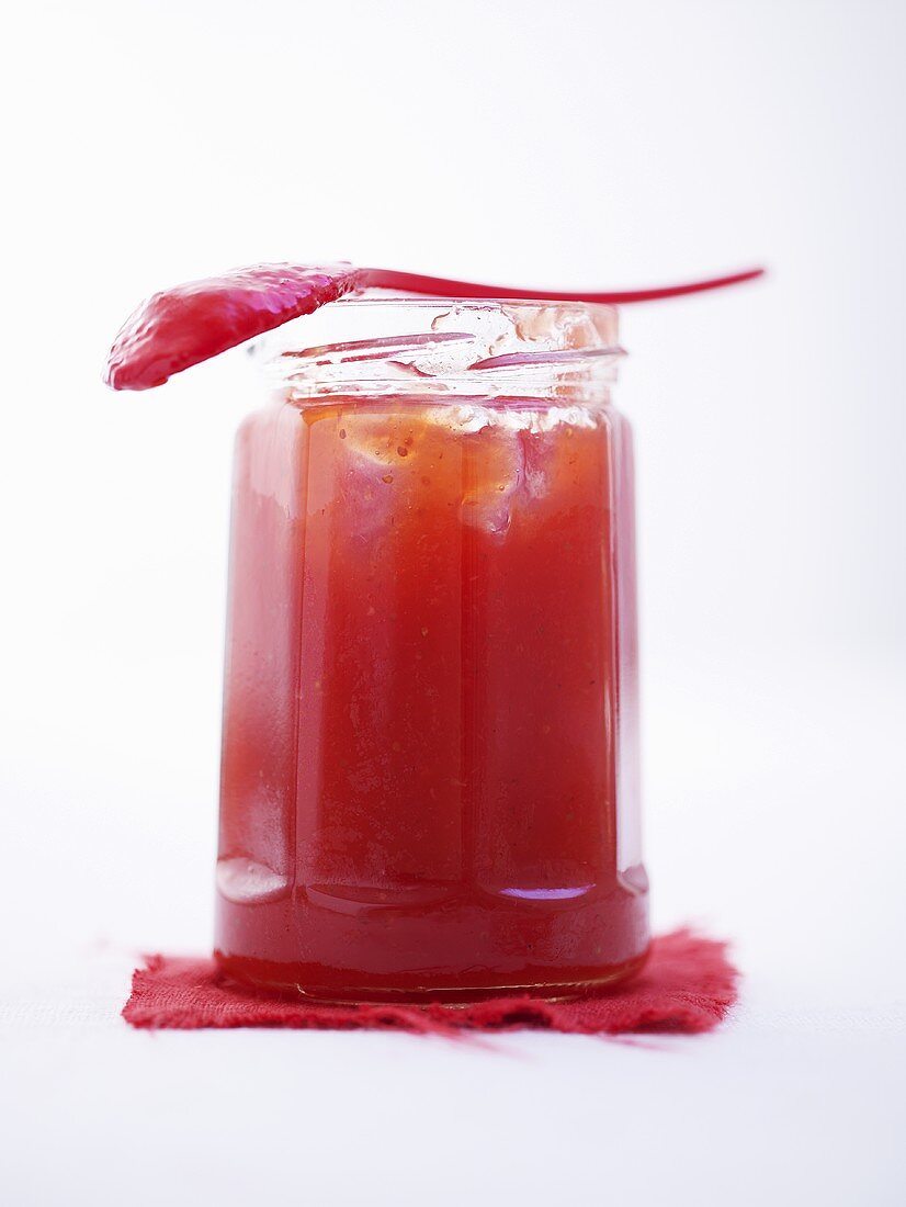 Jar of strawberry jam with spoon