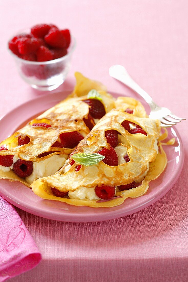 Löchrige Pfannkuchen mit Himbeeren und Sahne