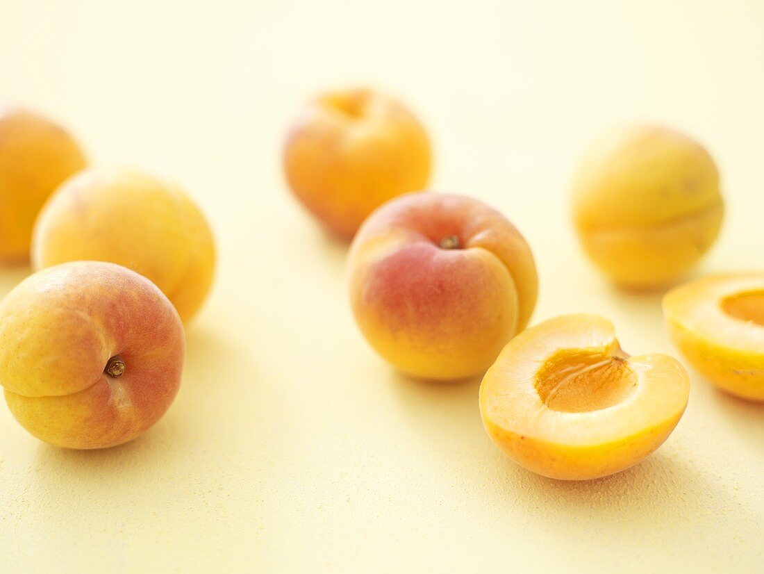 Mehrere Aprikosen, ganz und halbiert