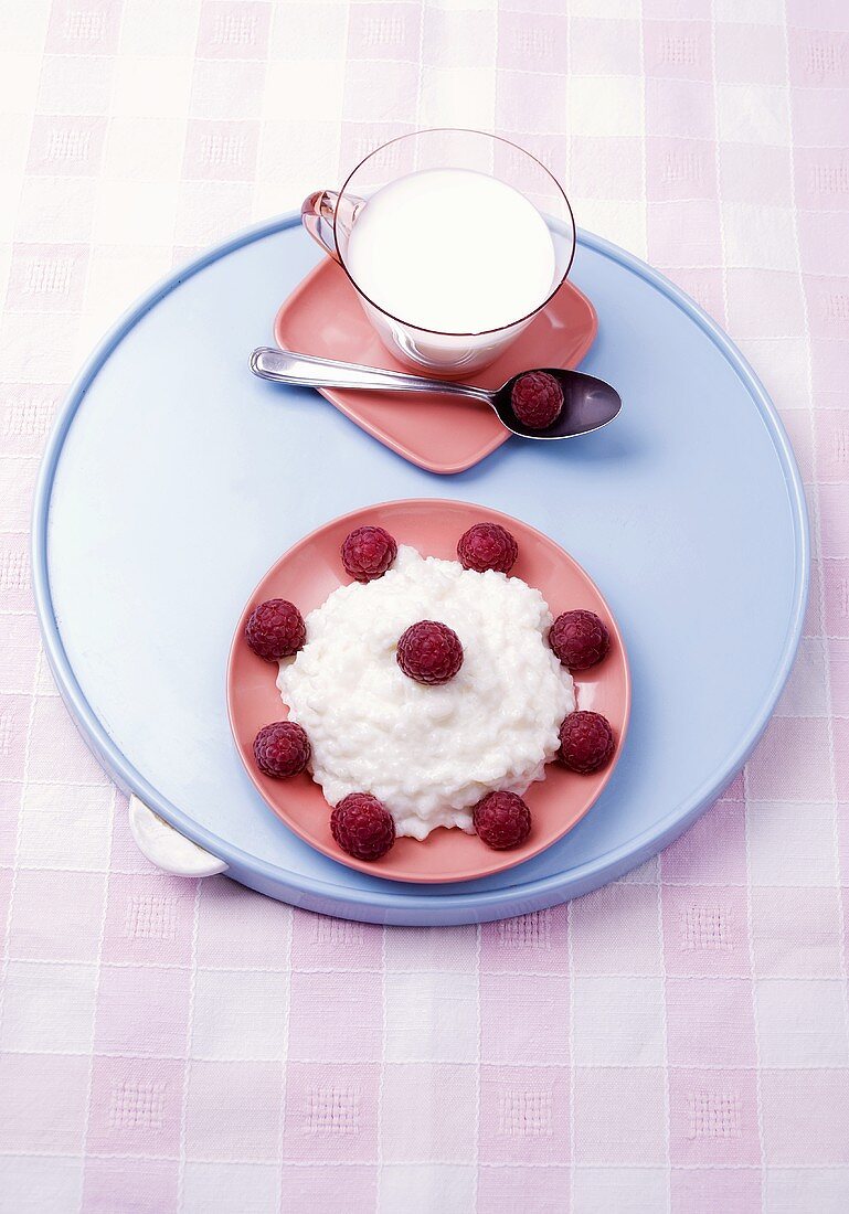 Rice pudding with raspberries and cup of milk