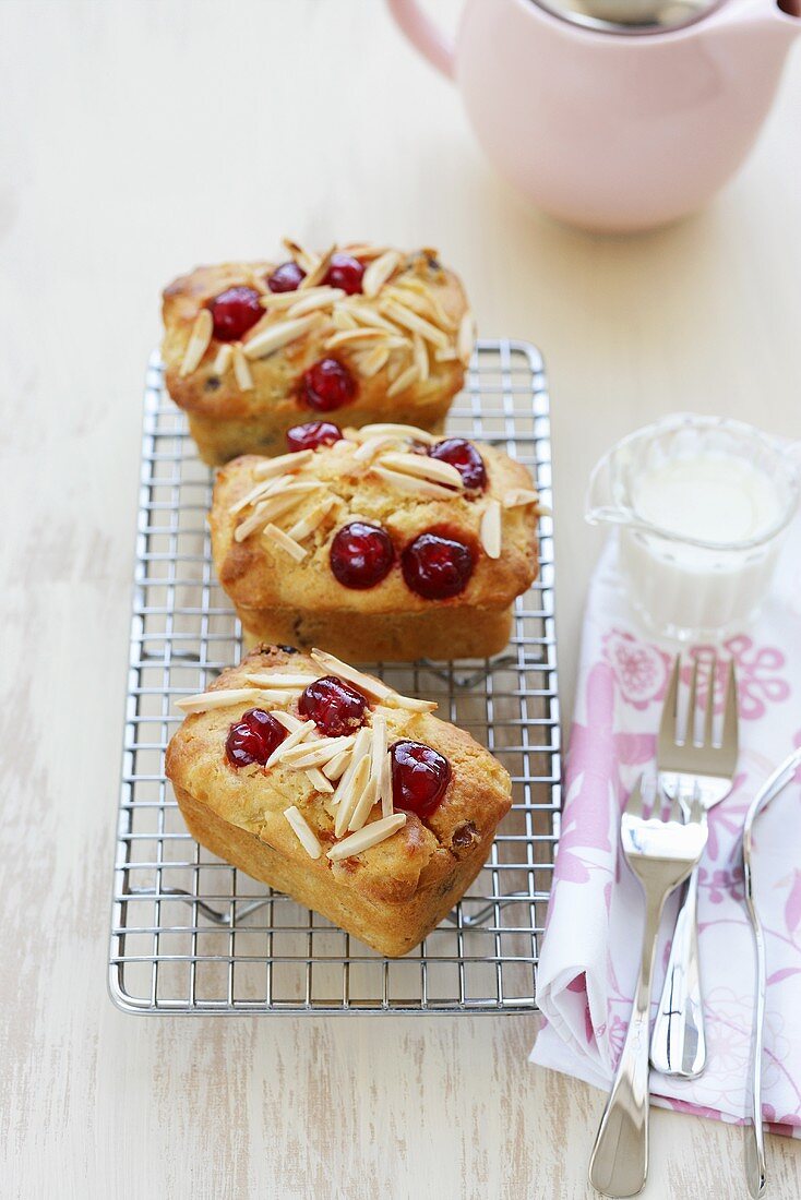 Friands with cherries and almonds on cake rack