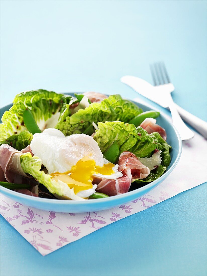 Blattsalat mit pochiertem Ei und Prosciutto