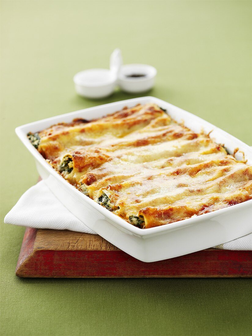 Cannelloni with ricotta and spinach filling in baking dish
