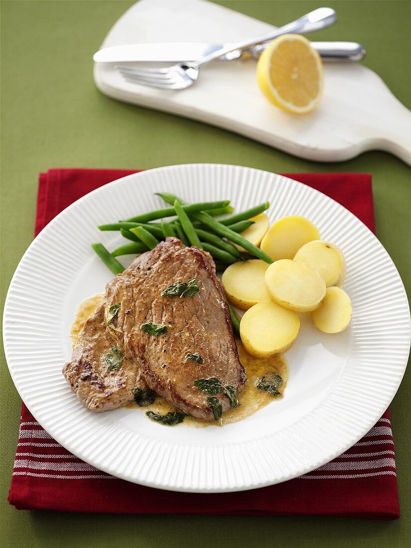 Kalbssteak mit Salbei-Zitronen-Sauce, Kartoffeln und Bohnen