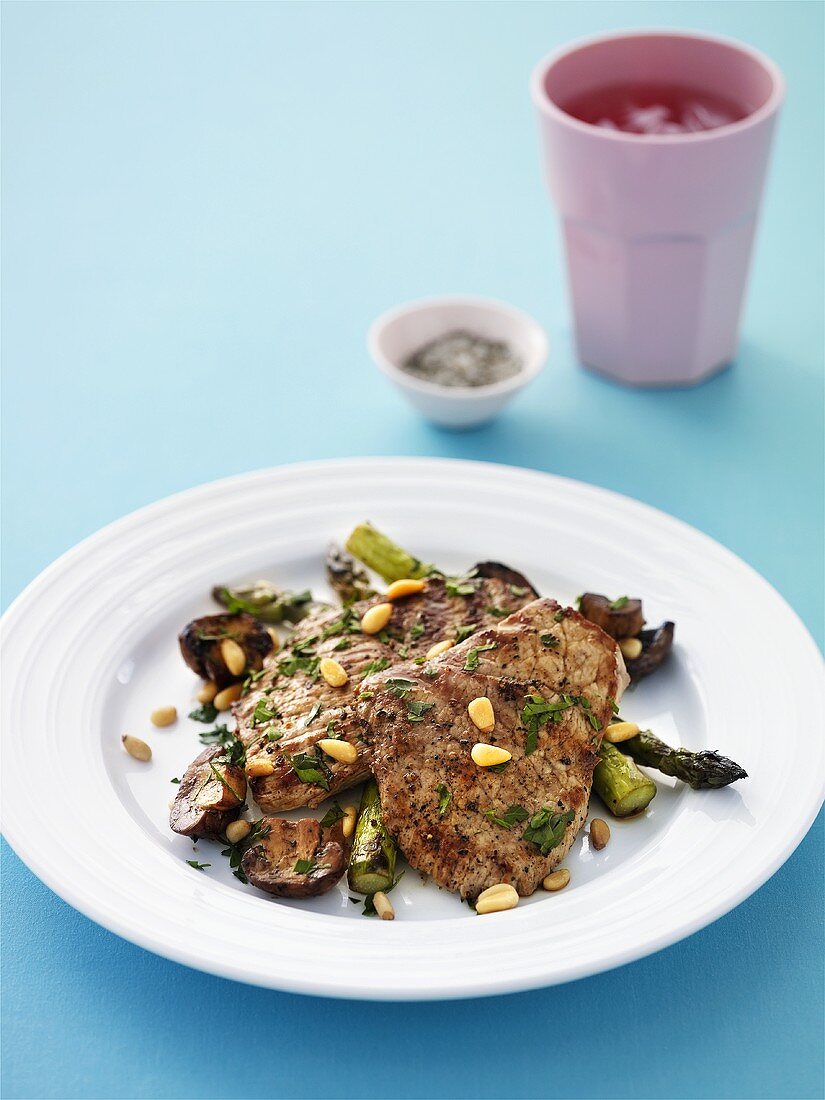 Steaks with grilled mushrooms, asparagus and pine nuts