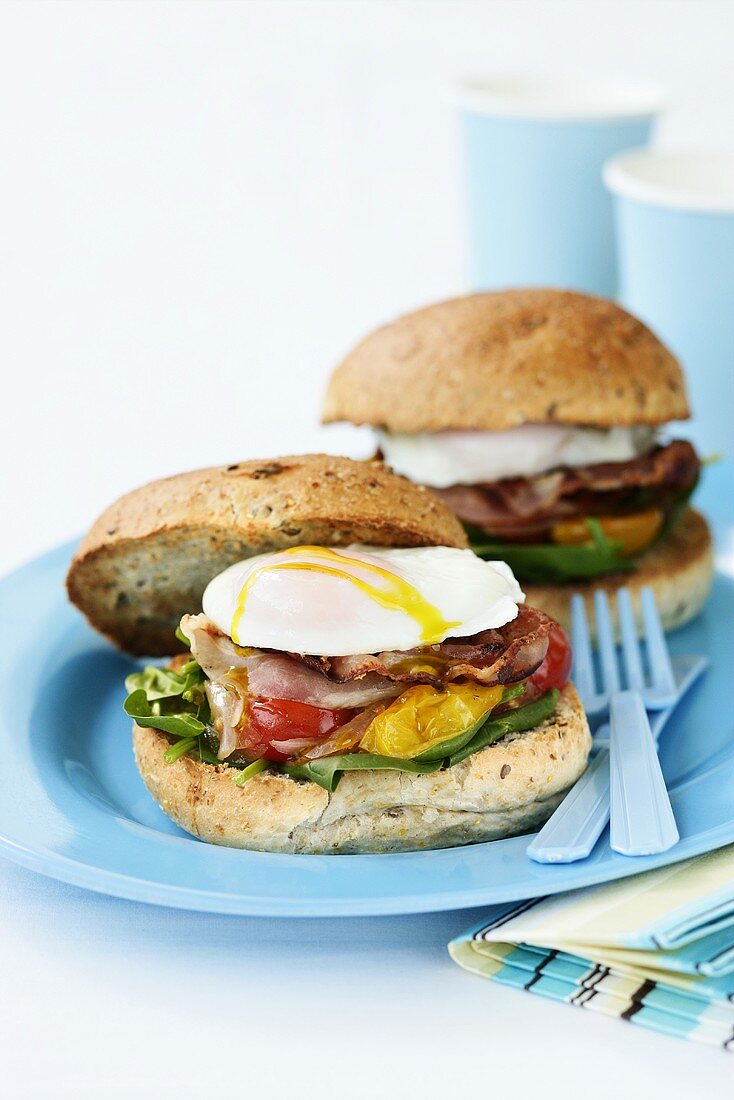 Poached egg and bacon in bread rolls for breakfast