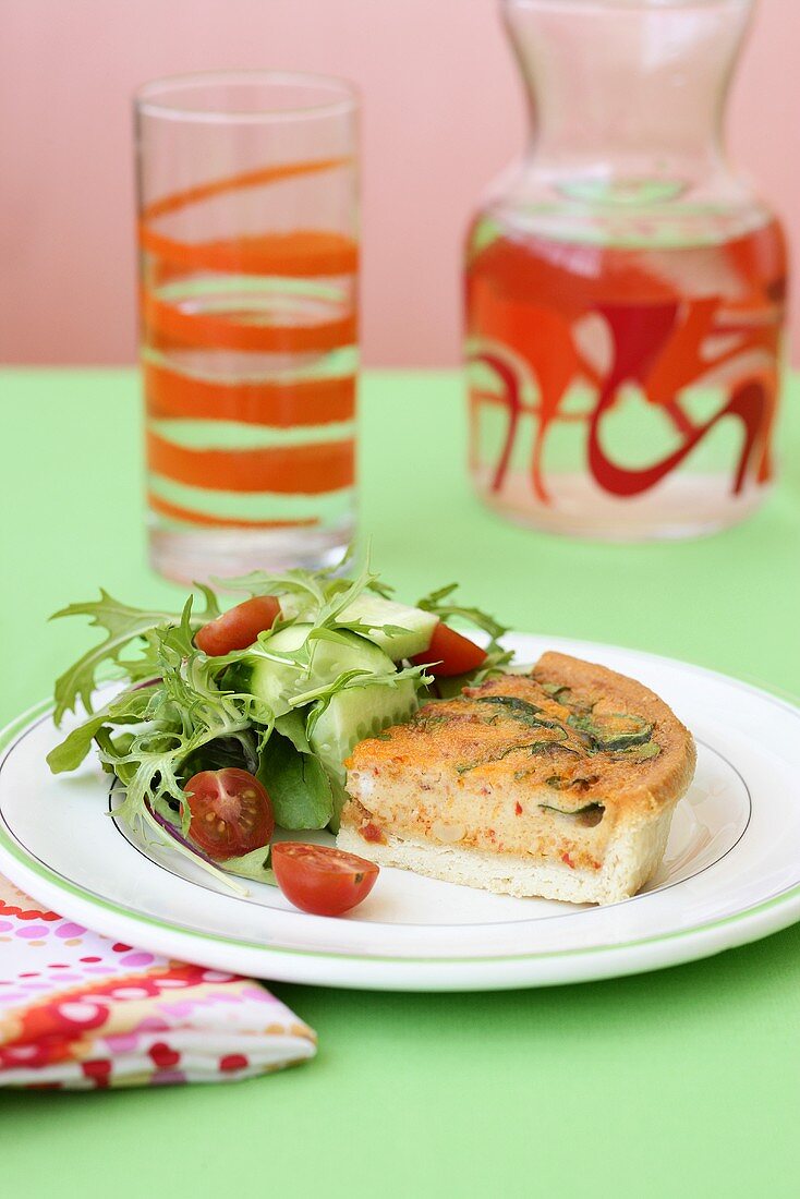 Piece of tomato and spinach quiche with salad