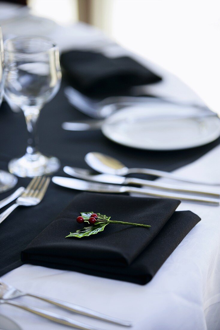 Gedeckter Tisch mit weißem Tischtuch und schwarzen Servietten