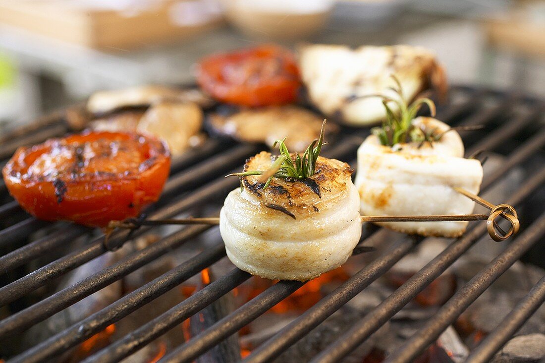 Aalröllchen mit Rosmarin und Tomatenhälften auf dem Grill