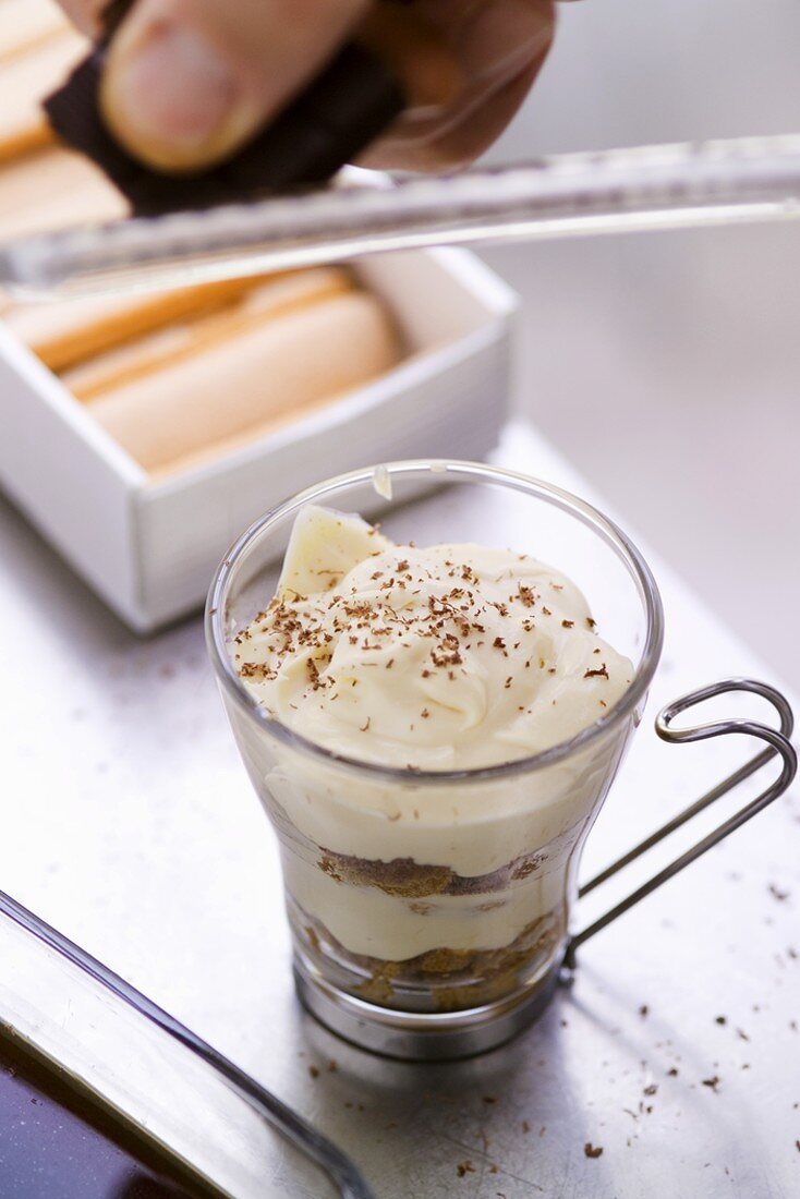 Schokolade über das Tiramisu raspeln