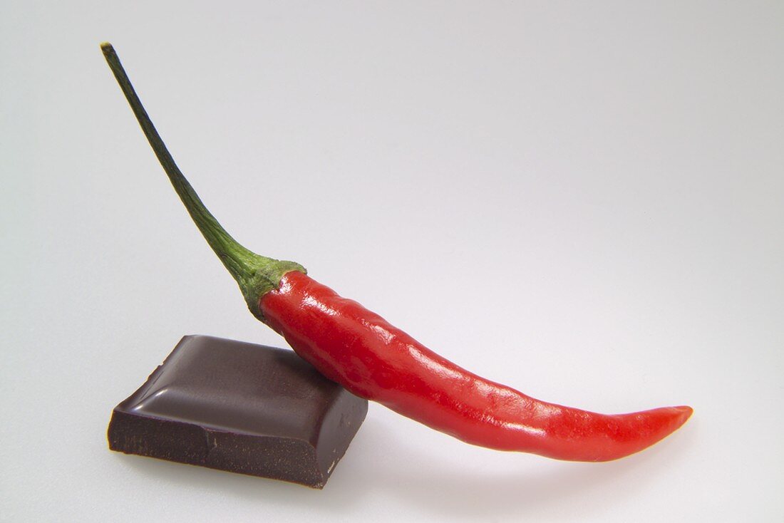 A piece of chocolate with a red chilli