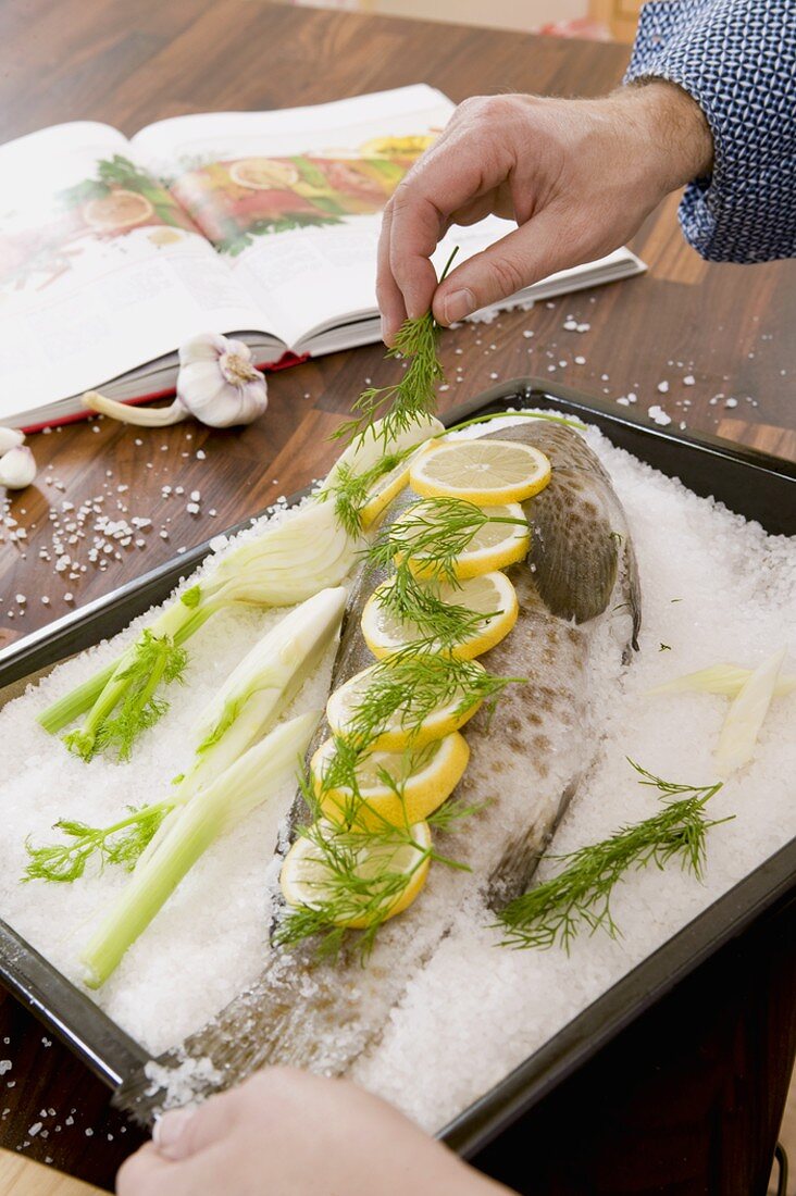 Fisch im Salzmantel zubereiten: mit Dill garnieren